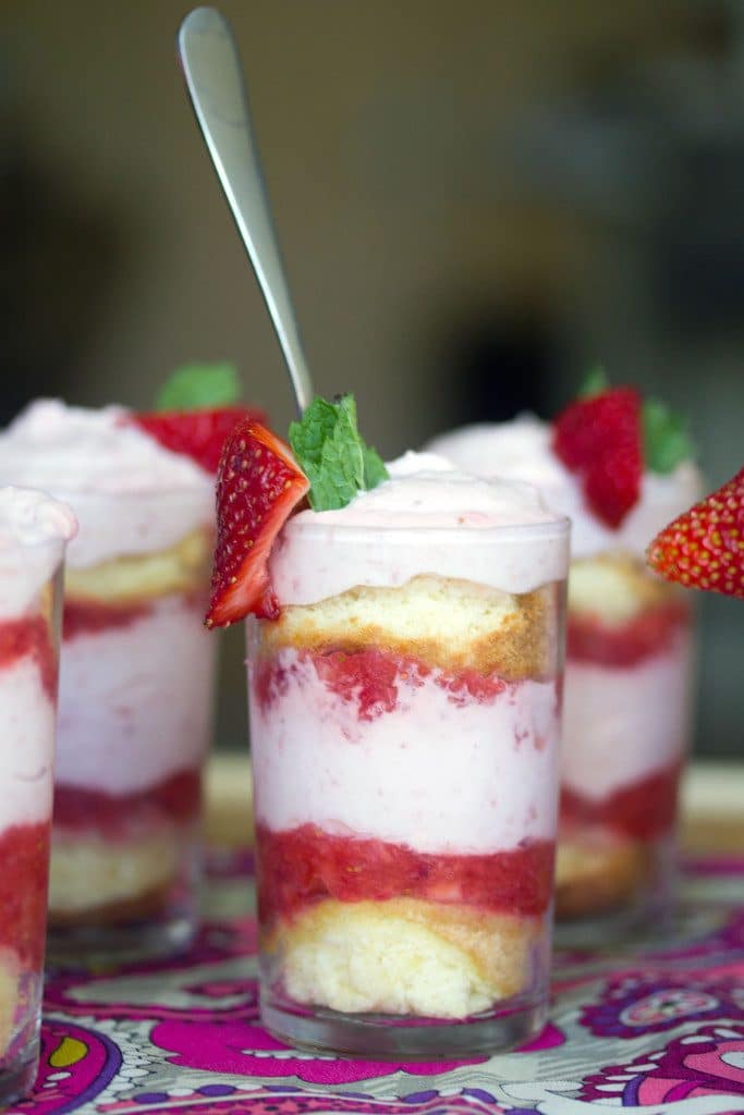 Closeup head-on view of a strawberry mousse parfait with layers of sponge came, strawberry purèe and strawberry mousse