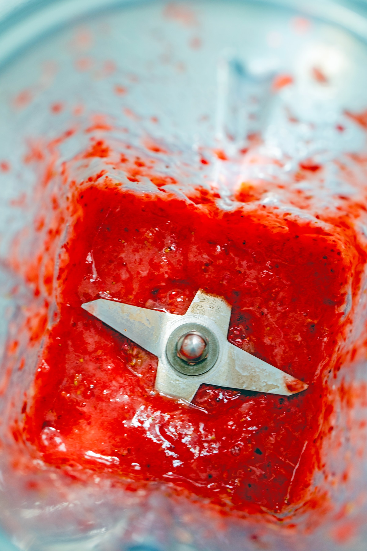 Overhead view of strawberry puree in a blender.