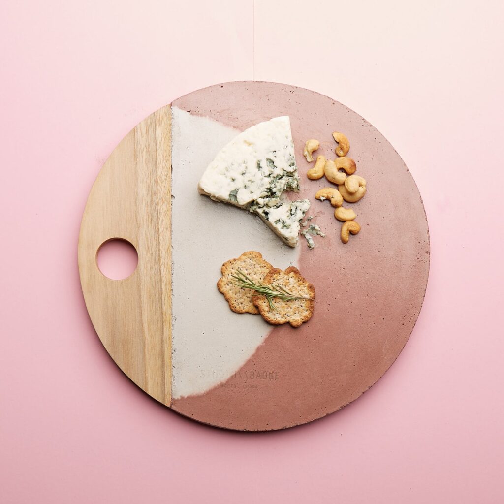 Studio Badge board with cheese, crackers, and nuts on it