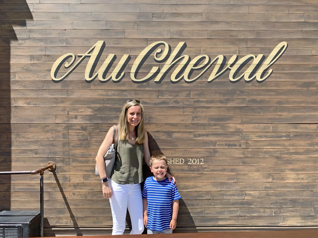 View of Sues and Henry standing outside of Au Cheval in Chicago