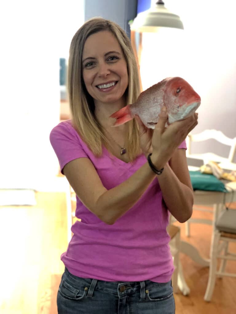 Sues holding a whole red snapper.