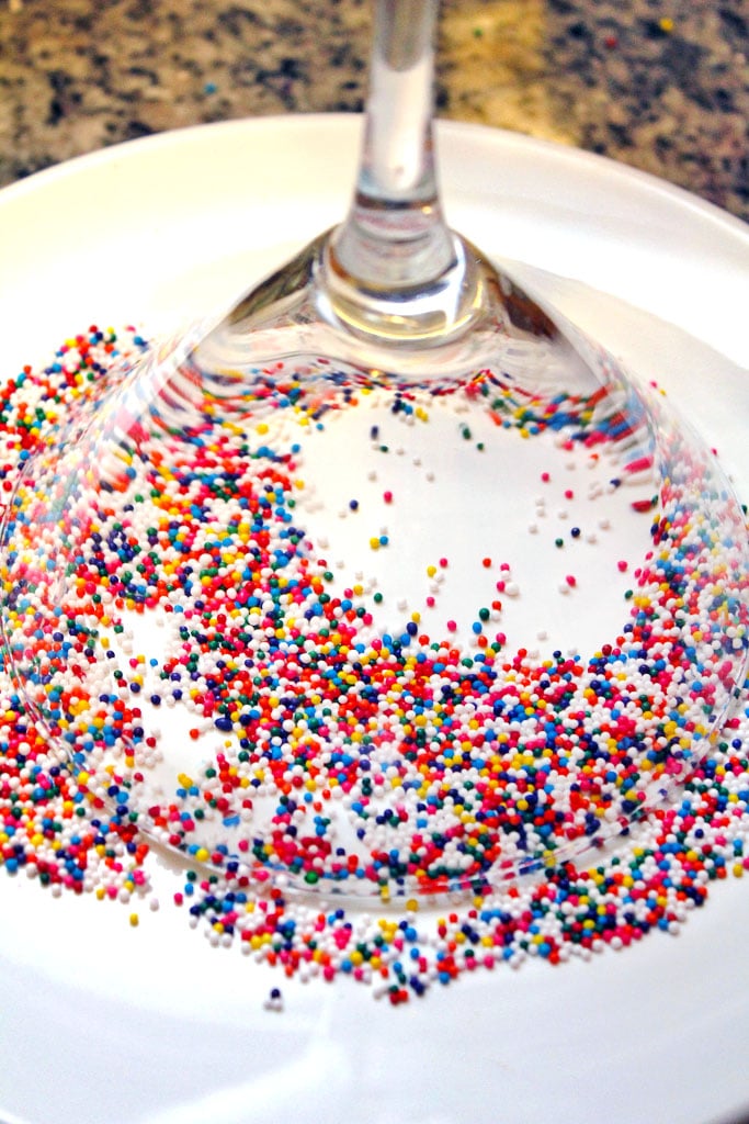 Martini glass upside down on a white plate with sprinkles