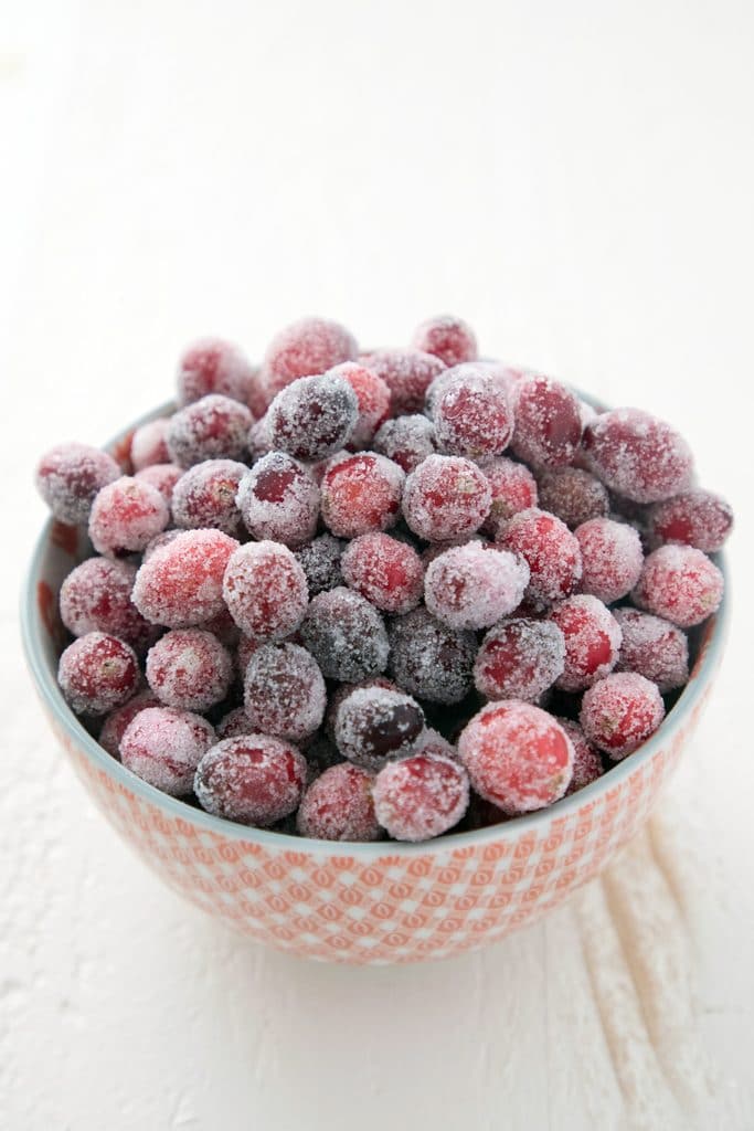 Head-on view of a red bowl of sugared cranberries