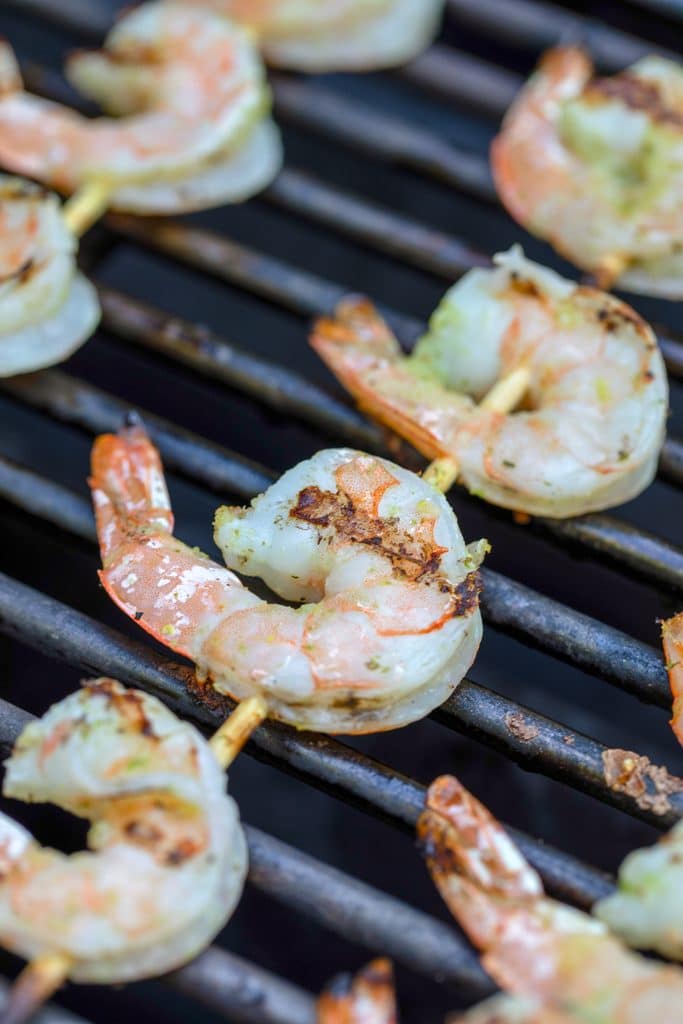 Shrimp skewers on grill turning pink.