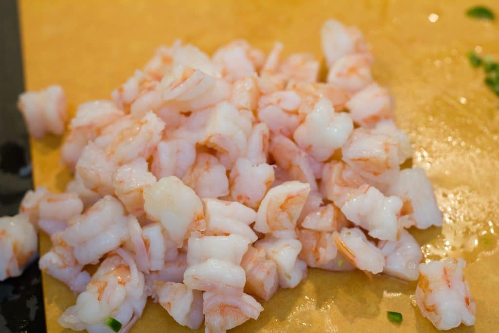 Overhead view of chopped shrimp on cutting board