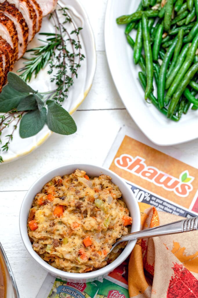 Overhead view of Thanksgiving stuffing with Shaw's flyer and turkey and green beans in background.