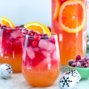 Tropical Cranberry Sangria -- Your favorite summer drink just transitioned to winter! This Tropical Cranberry Sangria is made with Mija Sangria, orange juice, and fresh cranberry juice. It will have you serving winter sangria all holiday season long | wearenotmartha.com