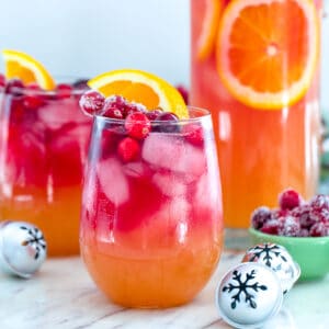 Tropical Cranberry Sangria -- Your favorite summer drink just transitioned to winter! This Tropical Cranberry Sangria is made with Mija Sangria, orange juice, and fresh cranberry juice. It will have you serving winter sangria all holiday season long | wearenotmartha.com #sangria #cranberries #holidays #christmas