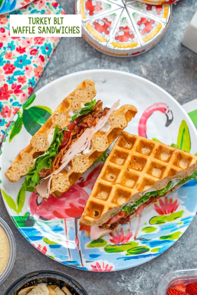 Overhead view of turkey BLT waffle sandwich on a fun flamingo plate with Laughing Cow cheese in background and recipe title at top