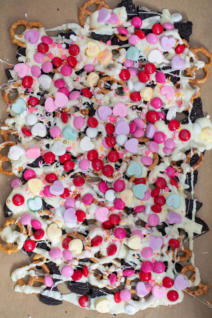 White chocolate and Valentine's Day candy sprinkled over pretzels and Oreo cookies.