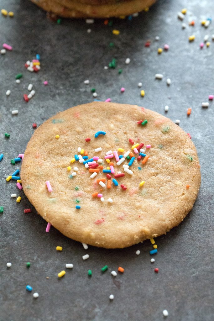 Overhead view of a single XL peanut butter cookie with sprinkles on top and all around