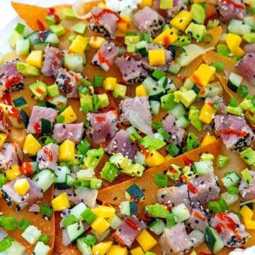 Closeup view of ahi tuna nachos with diced avocado, mango, and cucumber.