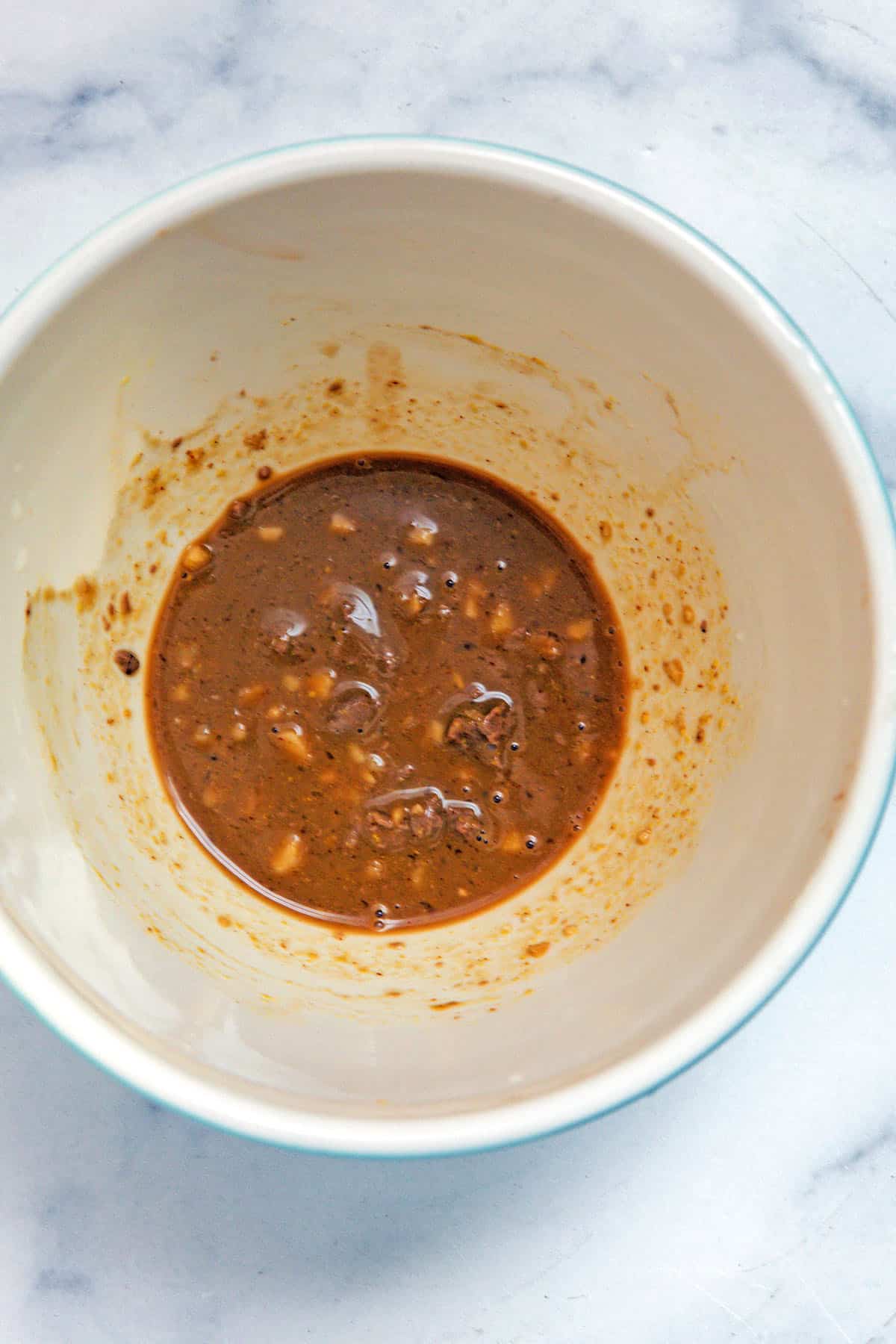 Chopped anchovies, Worcestershire sauce, garlic, and dijon in bowl.