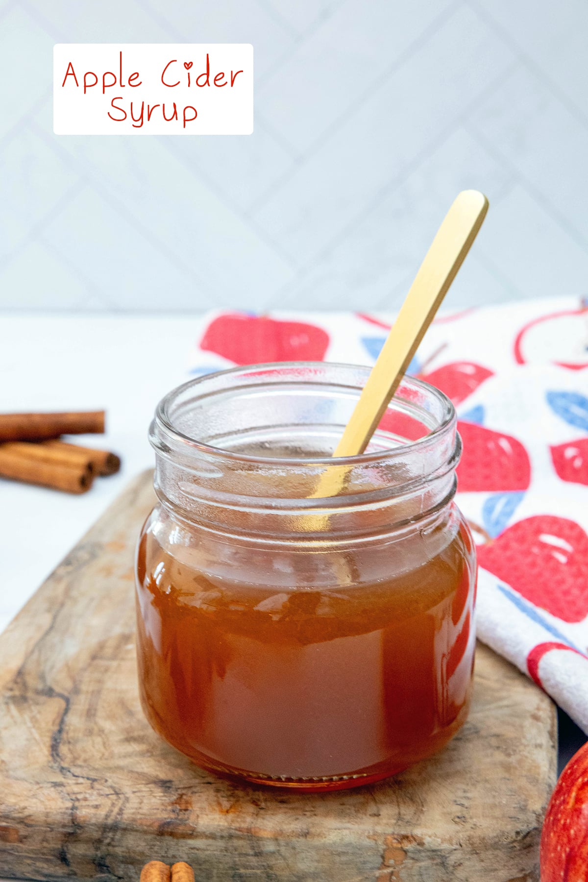 Apple cider syrup in a small mason jar with a spoon with recipe title at top.