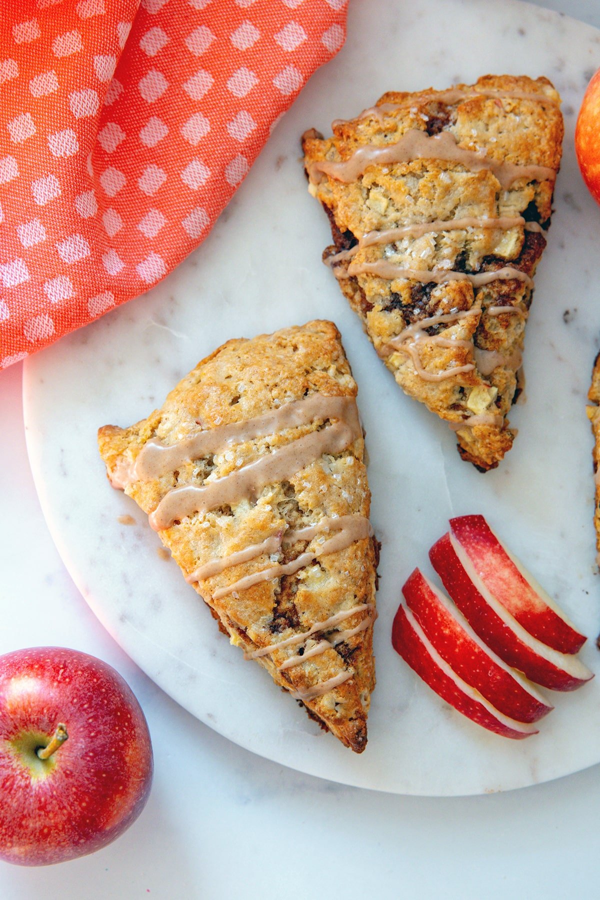 Overhead view of two apple cinnamon scones on a marble platter.
