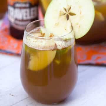 Closeup of a glass of an apple pumpkin shandy sangria with apple garnish.