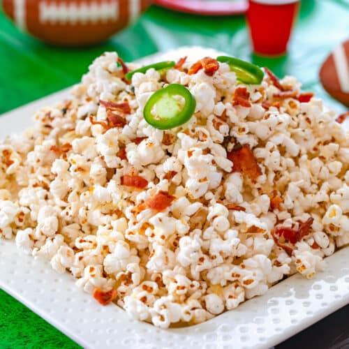 Closeup view of platter of popcorn with bacon and jalapeños.
