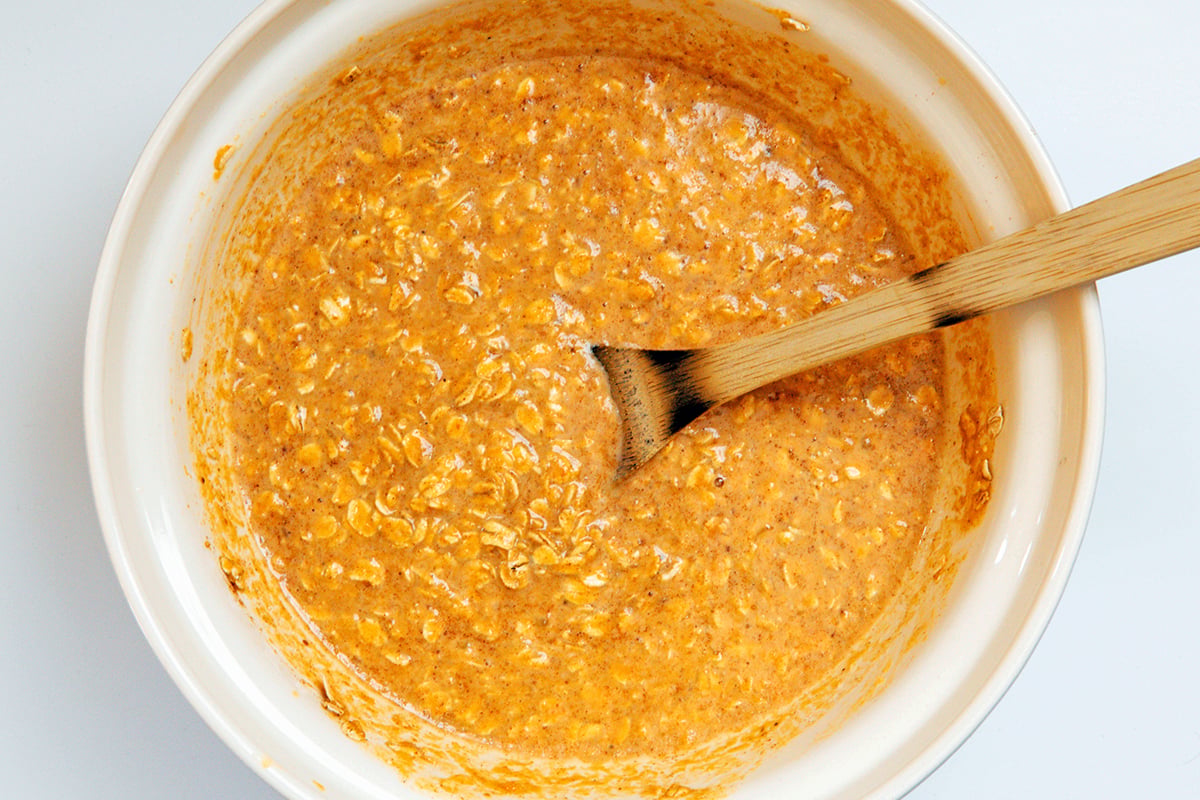 Baked pumpkin oatmeal mixture in mixing bowl.
