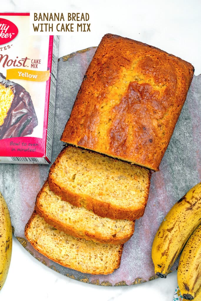 Banana bread with slices cut on pink marble board with box of cake mix and recipe title at top.