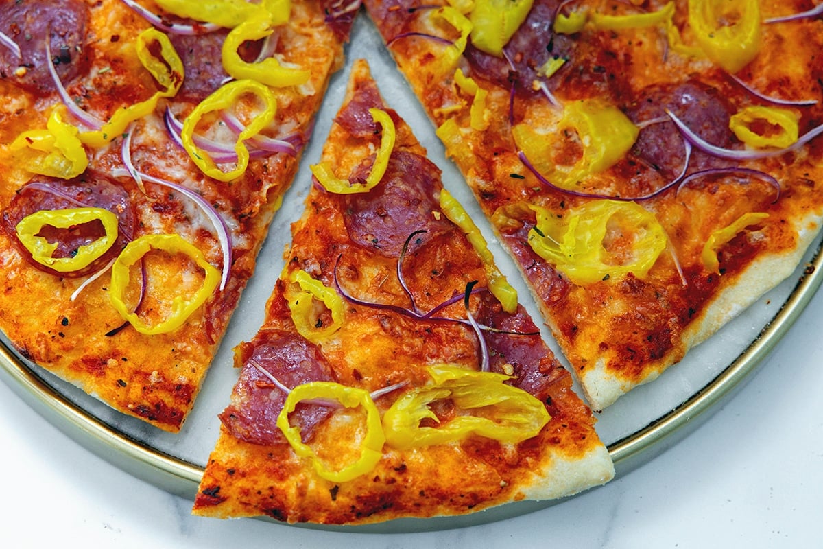 Landscape overhead closeup view of slice of banana pepper pizza.