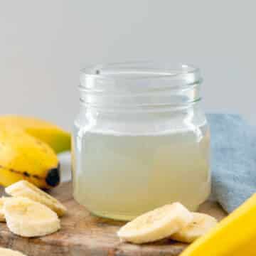 Closeup view of a small mason jar of banana syrup.
