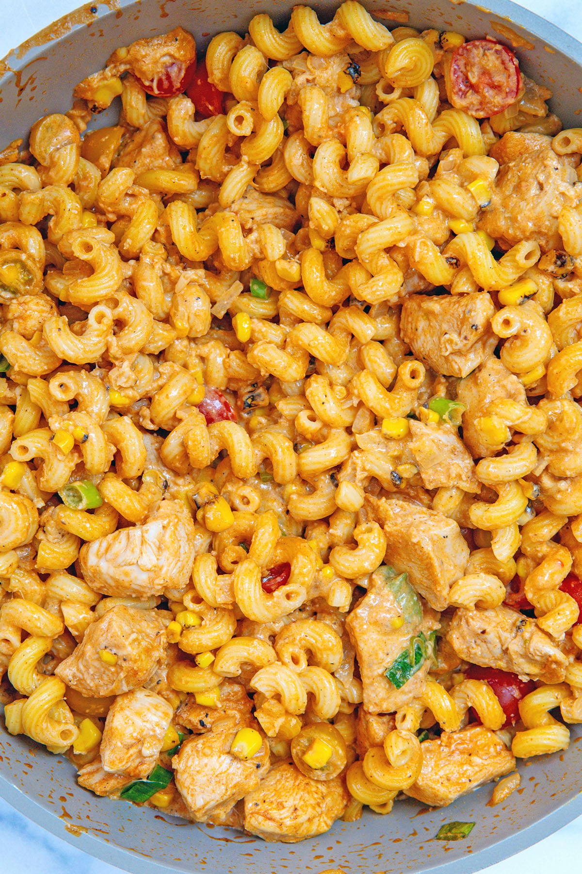 Pasta with chicken and BBQ sauce in skillet.