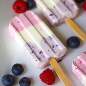 Closeup view of a berry greek yogurt popsicles with blueberries and raspberries.