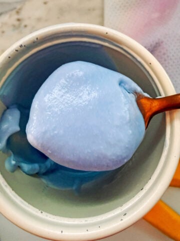 Blue toasted coconut cold foam on a spoon.