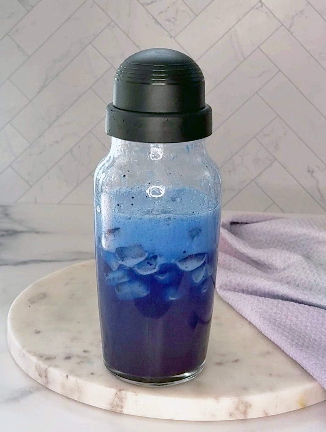 Blue Coconut Refresher ingredients shaken with ice in clear shaker.
