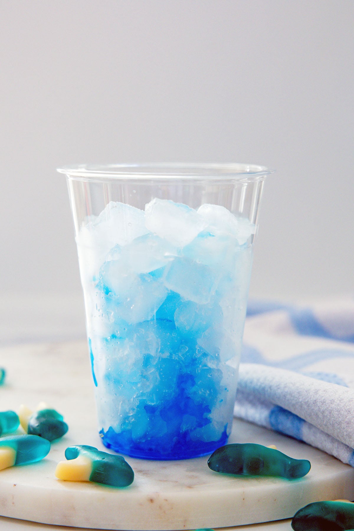 Blue coconut syrup drizzled over ice in cup.