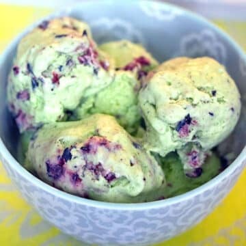 Closeup view of green kale and blueberry ice cream in a bowl.