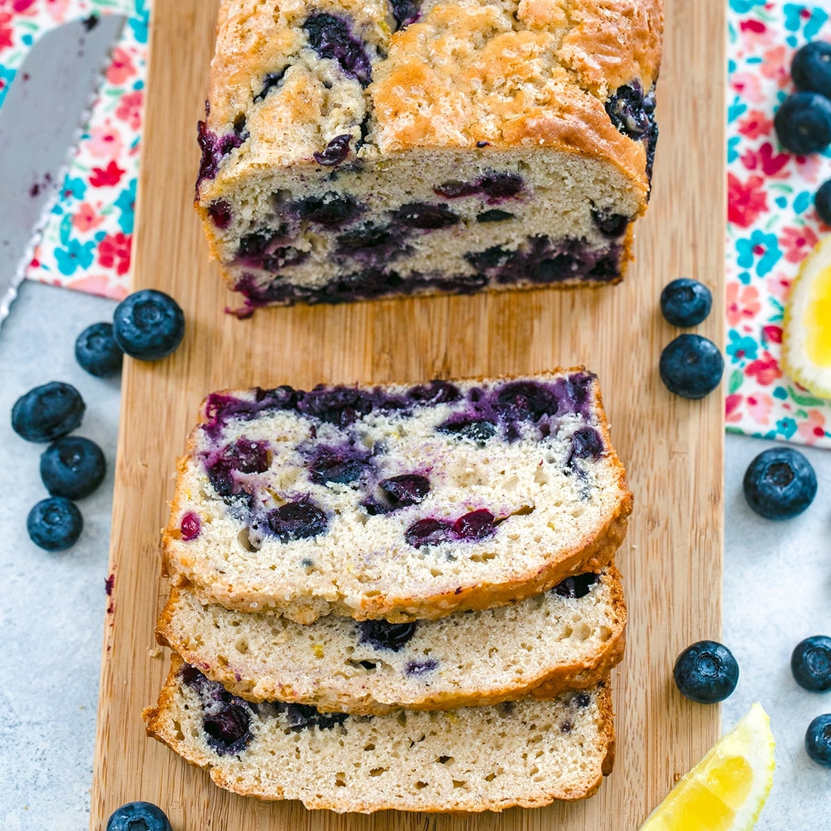 Closeup view of lemon blueberry bread sliced on wood cutting board.