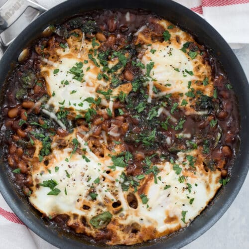 Overhead closeup view of a skillet with Boston baked beans and eggs.