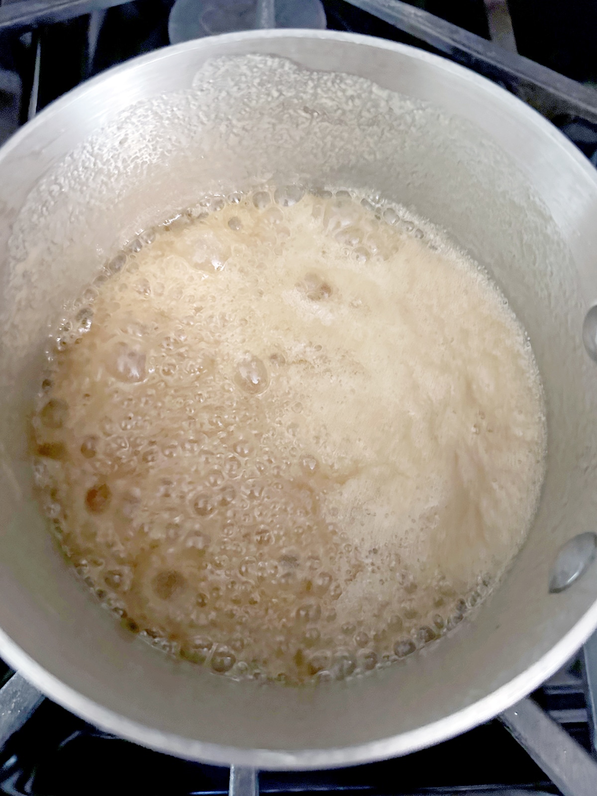 Brown sugar, butter, and cream simmering in saucepan.