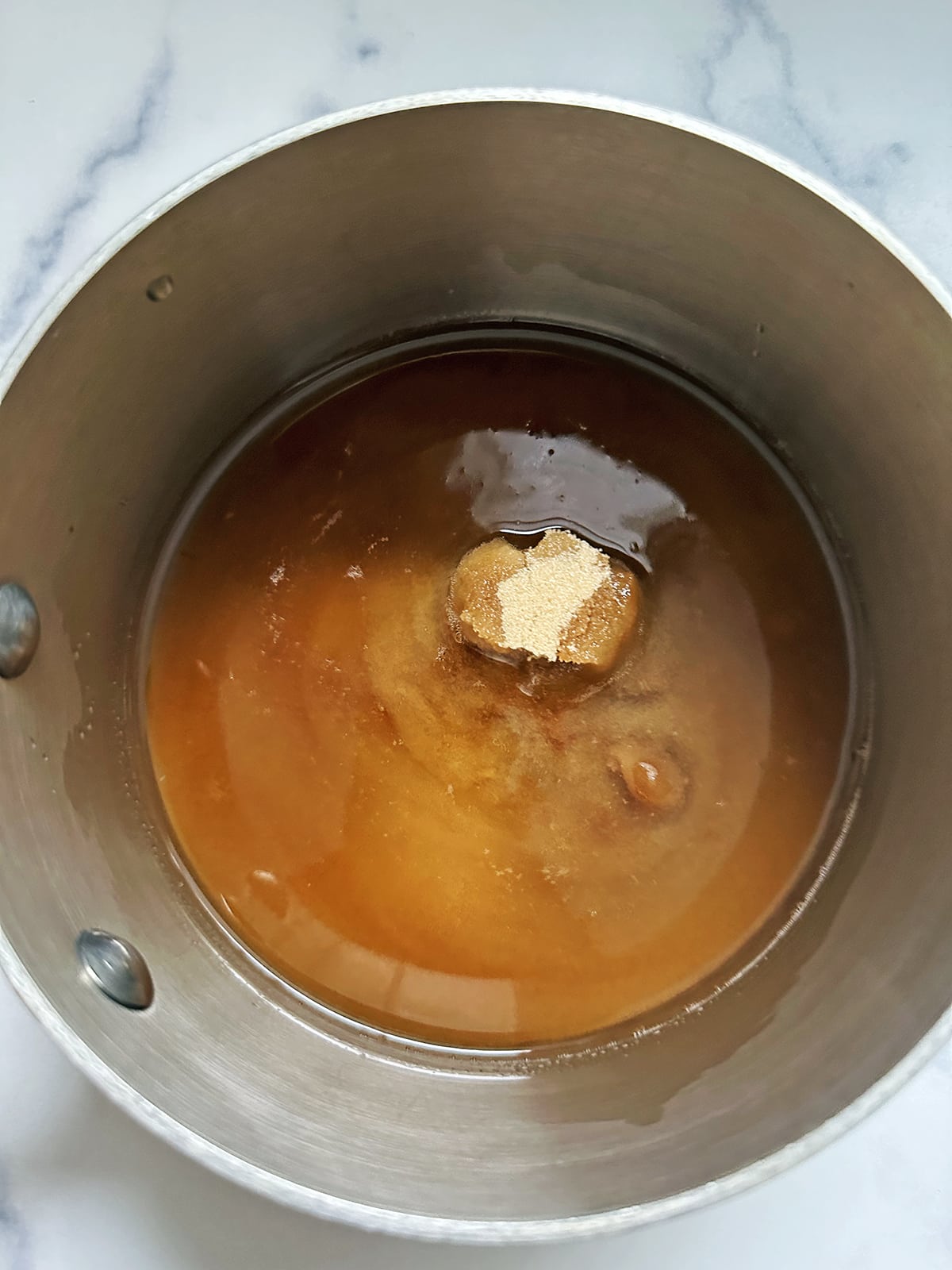 Brown sugar in saucepan with water.