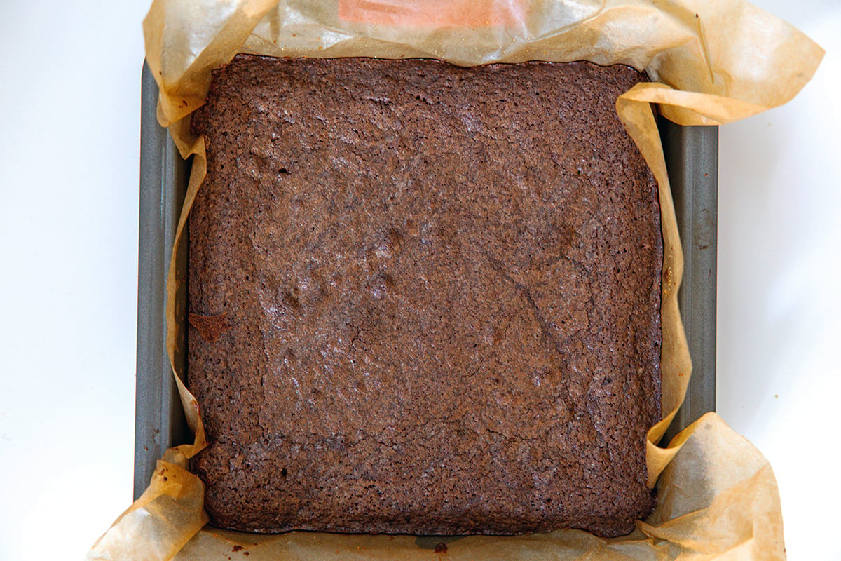 Baked brownie in pan over graham cracker crust.