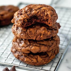 Close-up view of a stack of chocolate brownie mix cookies with a bite taken out of the top one.