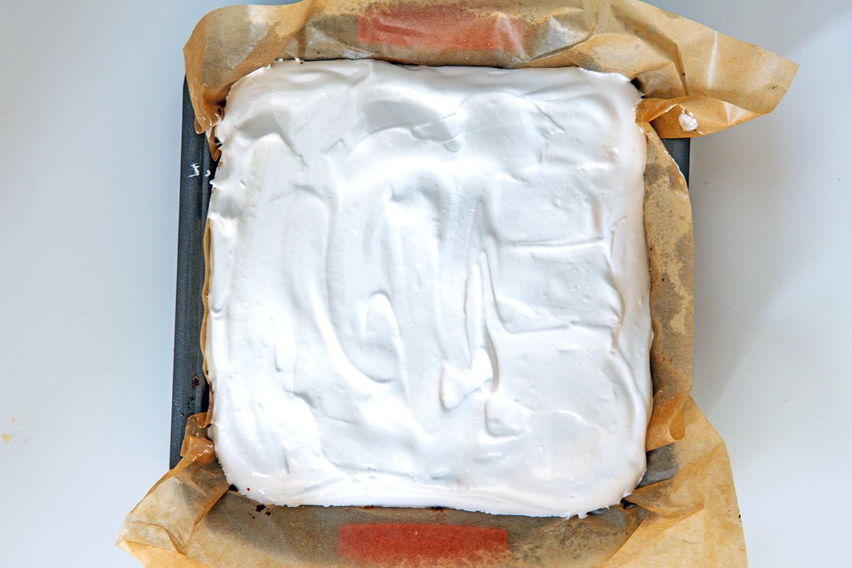 Marshmallow topping in pan over brownie layer.