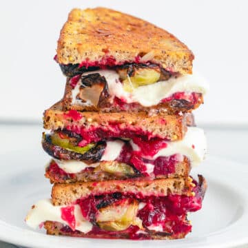 Brussels sprouts and cranberry relish grilled cheese sandwich halves stacked on each other.