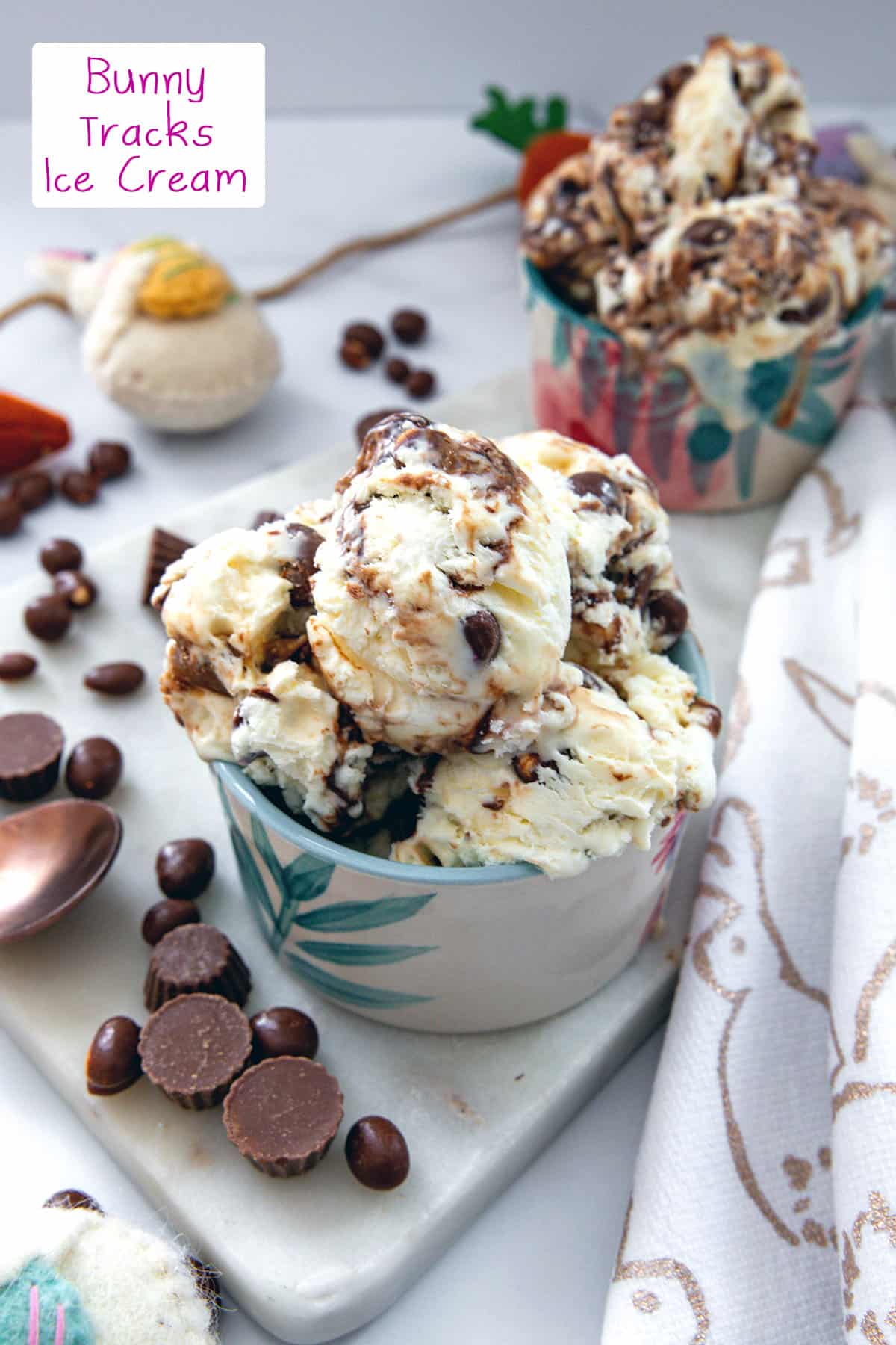 Two bowls of ice cream with mini peanut butter cups and chocolate peanuts all around and recipe title at top.