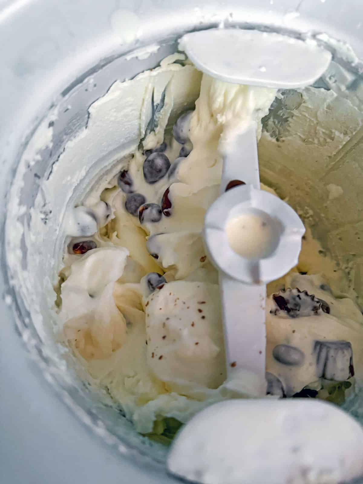Overhead view of vanilla ice cream with chocolate processing in ice cream machine.