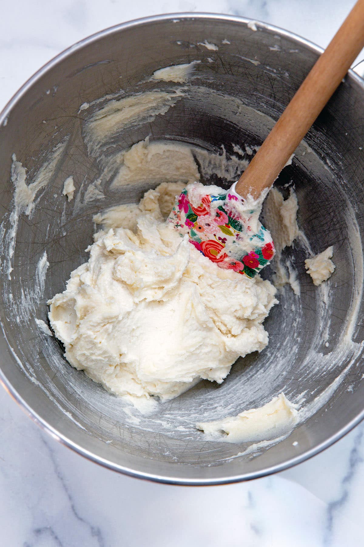 Butter and sugar creamed together in bowl with spatula.