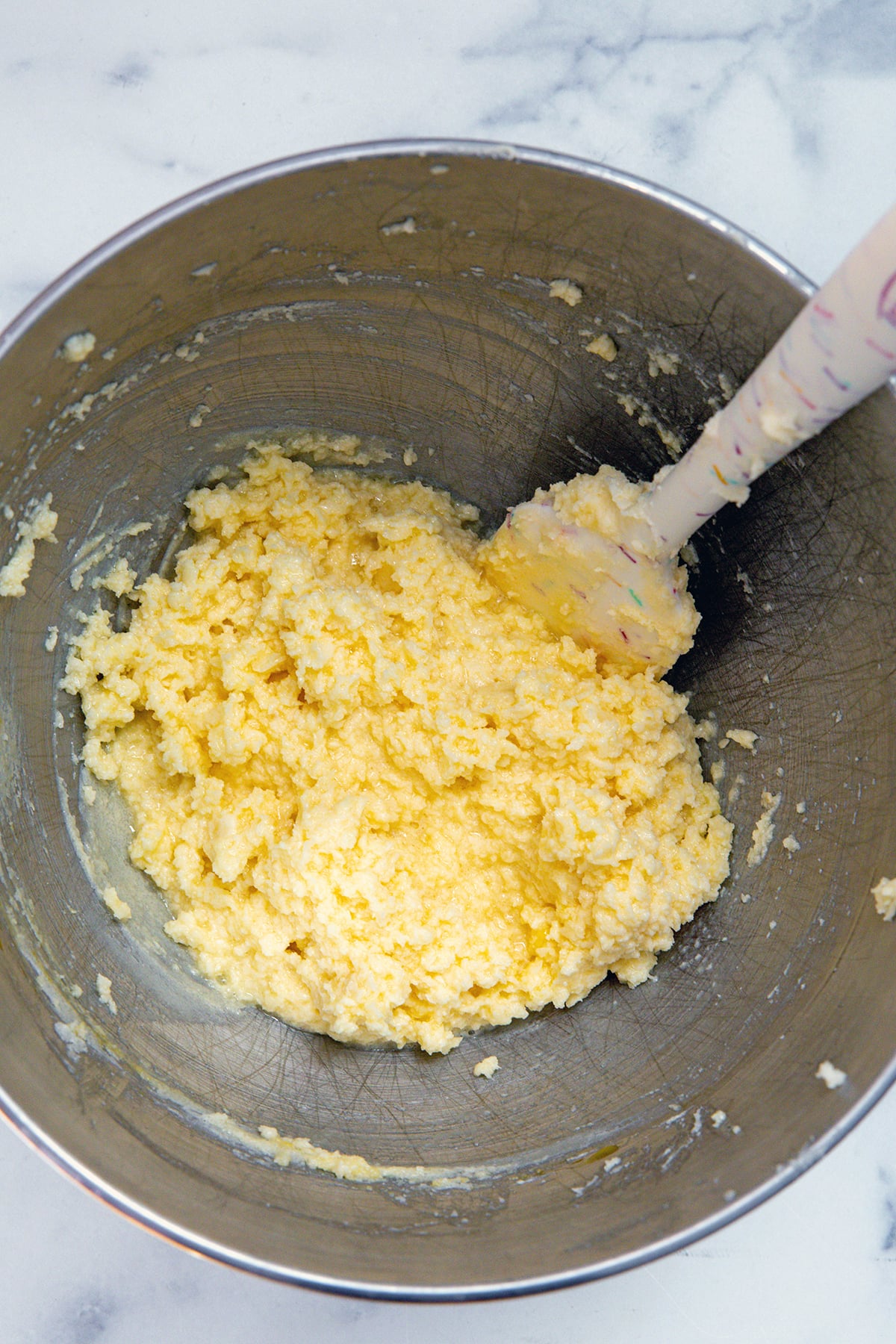 Butter, sugar, and eggs in a mixing bowl.