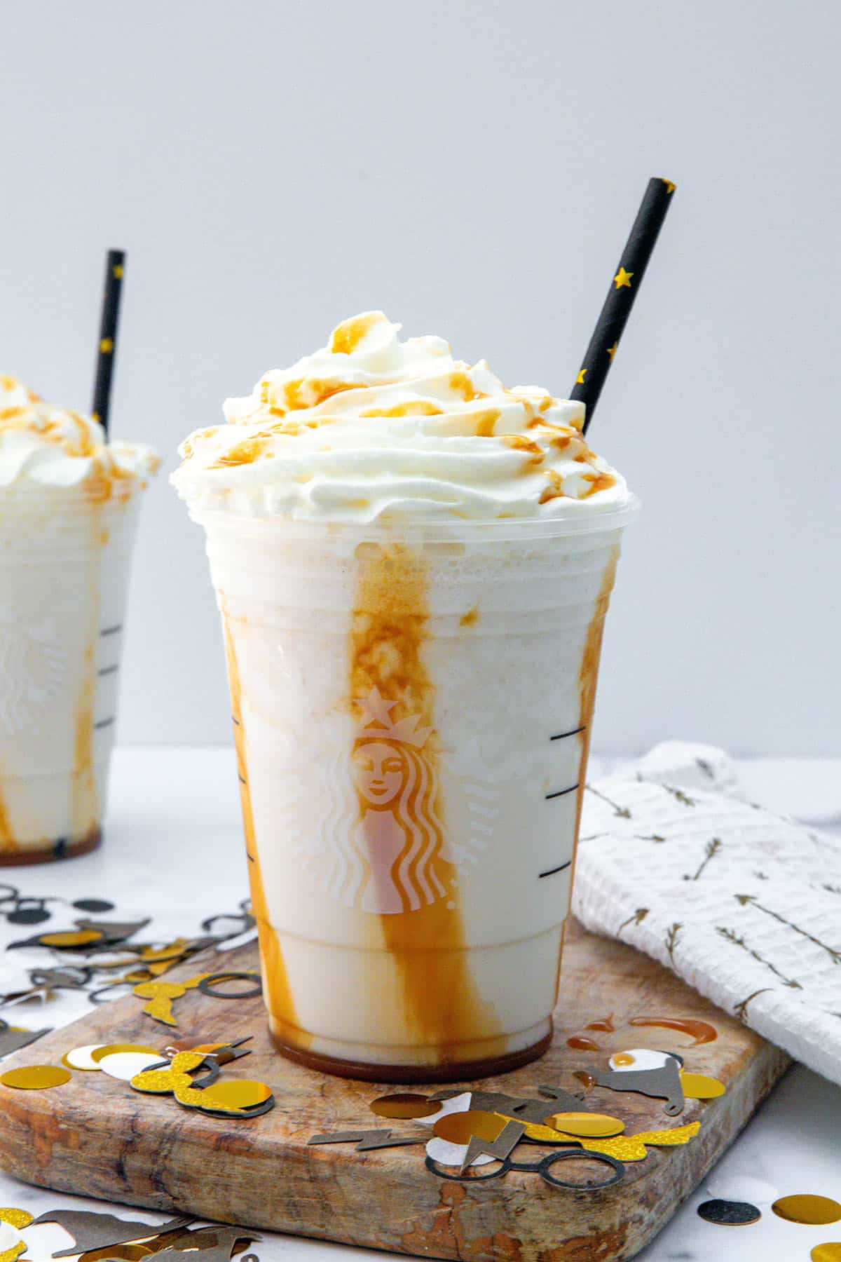 Head-on view of a Butterbeer Frappuccino with caramel swirl and whipped cream topping.
