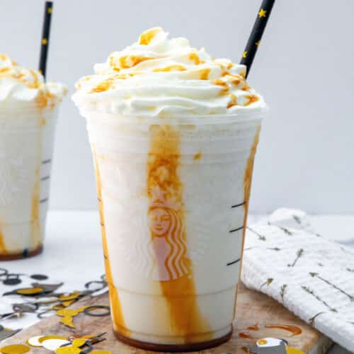 Closeup view of a Butterbeer Frappuccino topped with whipped cream and caramel.