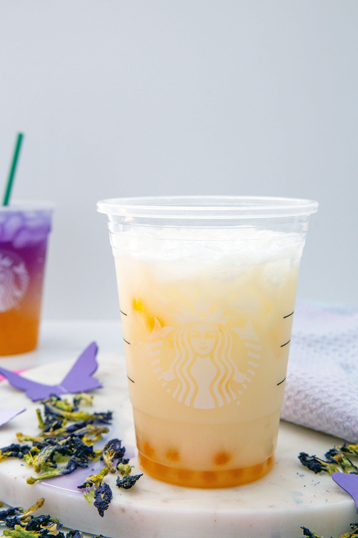 Head-on view of a Starbucks cup filled with popping pears and passionfruit-guava Refresher base with coconut milk.