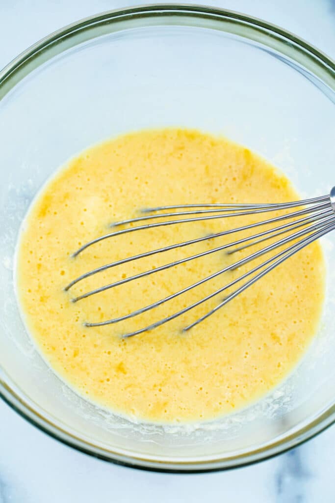 Buttermilk, butter, and eggs in mixing bowl with whisk.