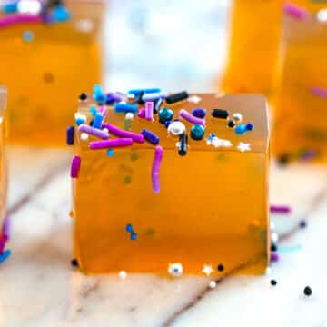 Closeup view of butterscotch jello shots topped with sprinkles.