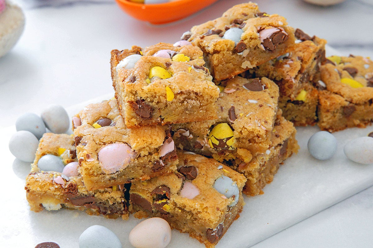Landscape overhead view of Cadbury Mini Egg blondies on a marble tray.
