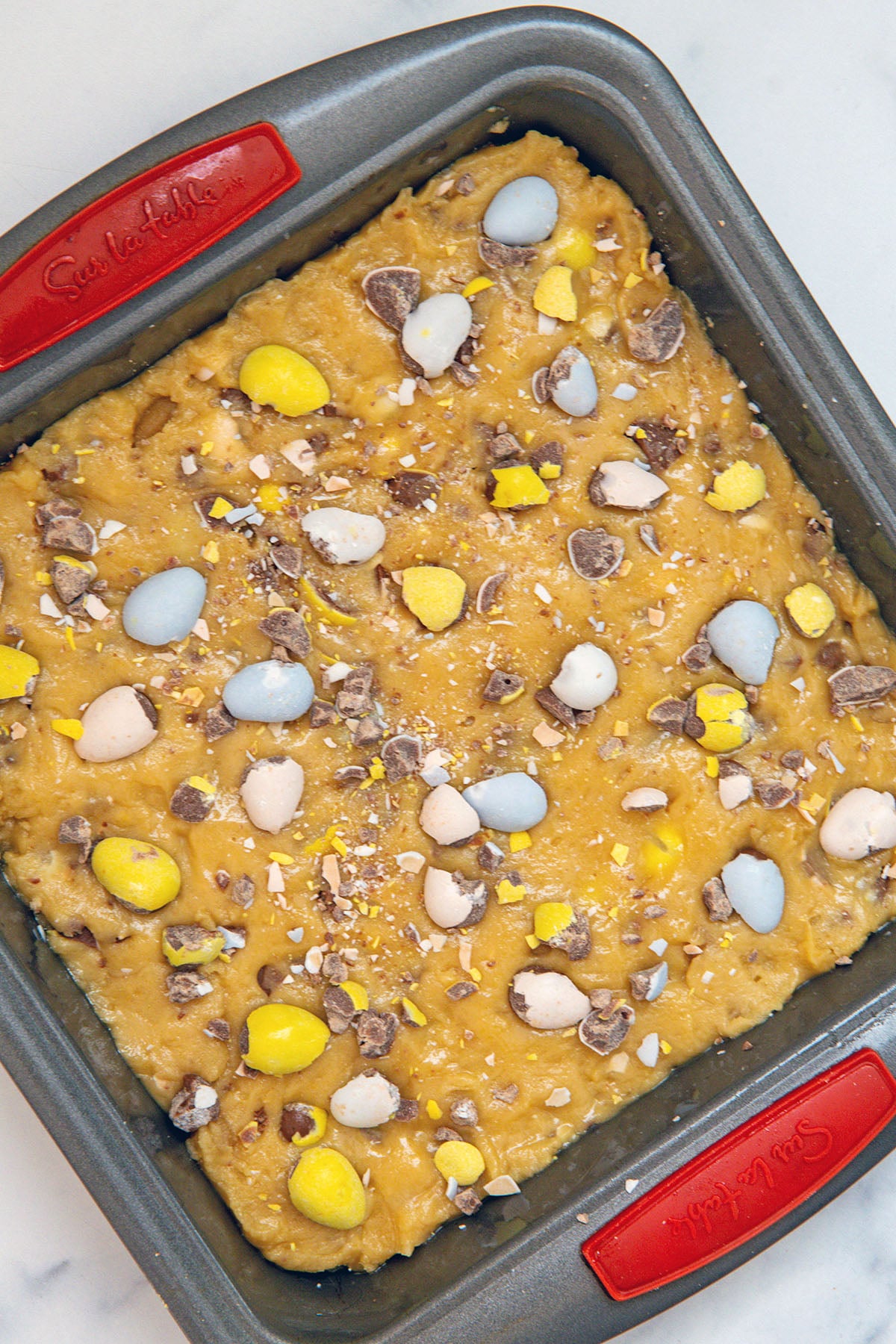 Cadbury Mini Egg blondie batter pressed into pan.